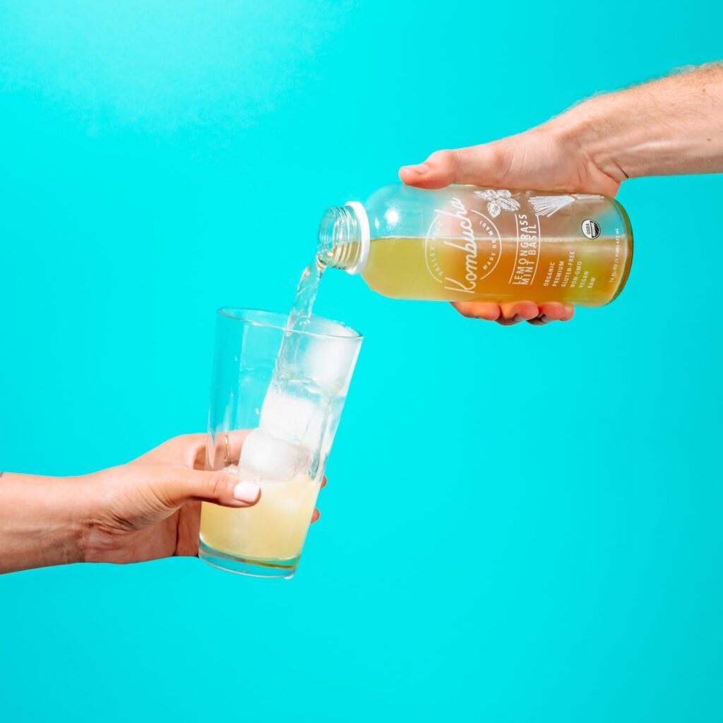 person holding clear drinking glass with beer